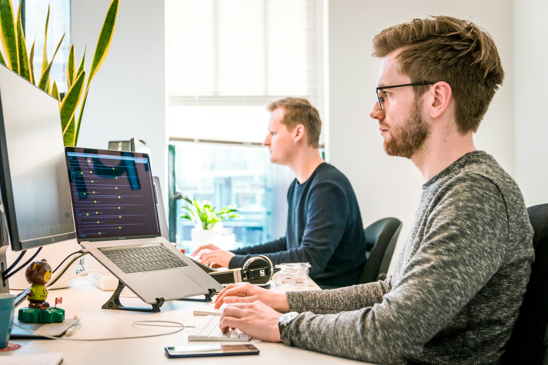 Two colleagues working at computers in a bright office